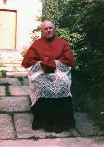 063 Župnik Ivšić sjedi ispred sakristije